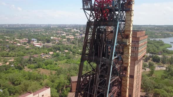 Headframe. Iron ore mining in the city center. Red mine in the industrial city.