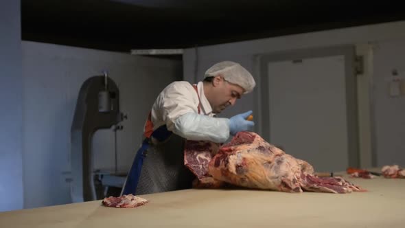 Cutting Meat Carcass of Animal on Table in Slaughterhouse