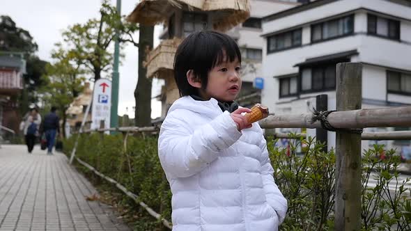 Little Asian Child Smiling  And Eating Ice Cream Outdoor