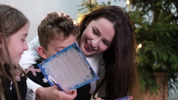 Mom and Children Read a Book They Have Fun Laughing Together