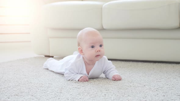 Happy Baby Lying on Carpet Background, Smiling Infant Kid Girl in White Clothing