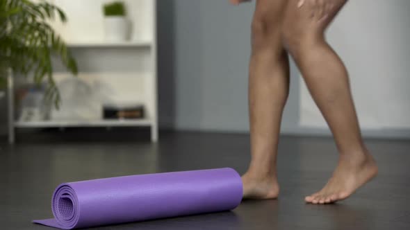 Young Woman Picking up Yoga Mat from The Floor, Getting Ready for Gym, Activity