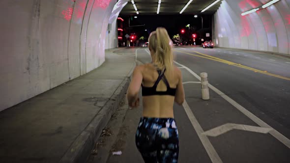 Attractive Woman Jogging Through A Tunnel