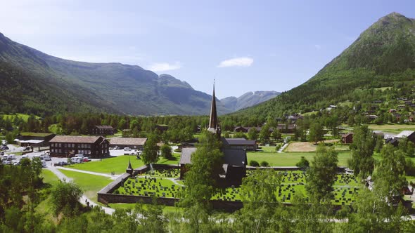 Revealing Shot Behind Trees Of Triple Nave Stave Church In The Municipality Of Lom. Lom Stavkyrkje I