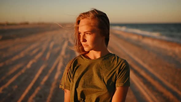 Worried Serious Woman Alone on the Beach Looking at Camera