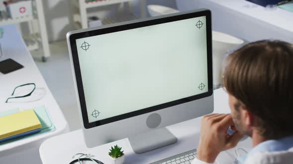 Caucasian male doctor having video call consultation using desktop computer
