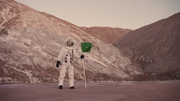 Astronaut By the Hills with the Flag Closes the Partition of the Helmet