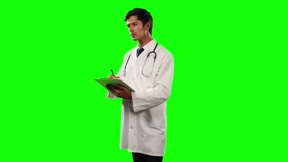 Side view of a doctor using his digital tablet with green screen