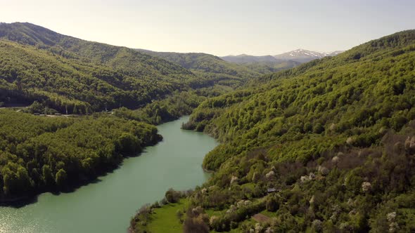 Slow flyover above narrow lake formed by Maneciu Dam, Romania. Dolly in