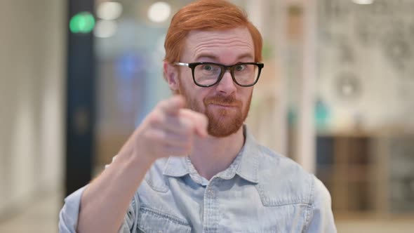 Portrait of Assertive Casual Redhead Man with Pointing and Inviting 