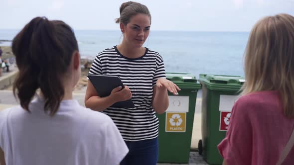 Smiling Beautiful Caucasian Young Woman Explaining Beach Cleaning Plan to Volunteers Talking