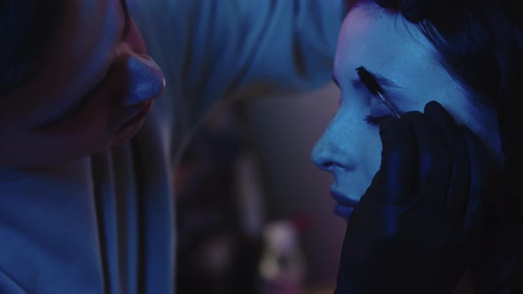 A Man Makeup Artist Brushing Hairs of His Female Client's Brows