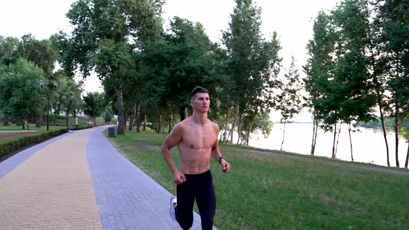 Sporty Man with Muscular Body Running at River Outdoor Morning Run