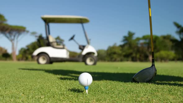 Golfer placing golf ball on tee