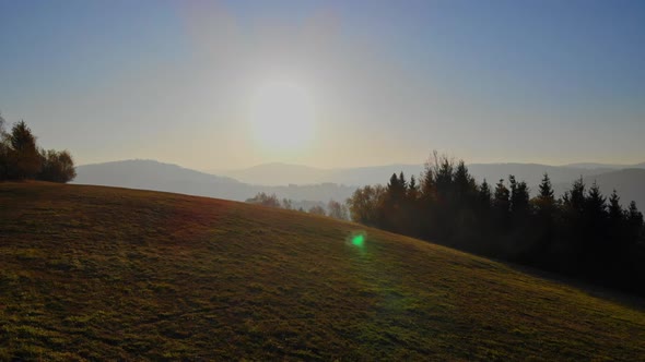 Flight over autumn mountains in the light of the setting sun