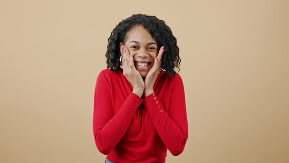 Young Happy African American Lady Enjoying Good News Touching Her Cheeks in Amazement and Laughing