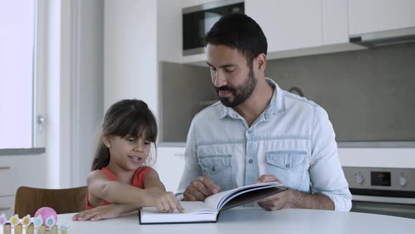 Dad Helping Little Daughter To Learn To Read