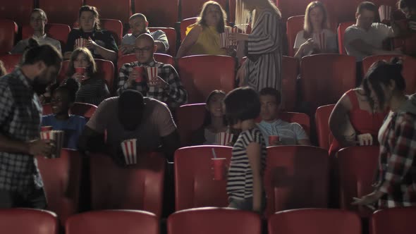 Diverse Audience Taking Seats in Cinema Hall