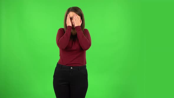 Pretty Girl Examines Something Then Fearfully Covers Her Face with Her Hands, Green Screen