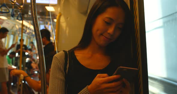 Woman use of smart phone on train in Hong Kong city