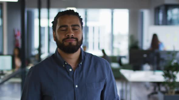 Portrait of mixed race businessman standing in office smiling to camera