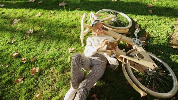 Woman Reading a Book with Wooden Eco Bicycle