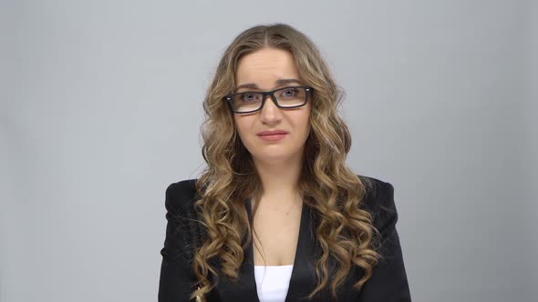 Bussines Woman Stands Worrying in Expectation at Grey Background