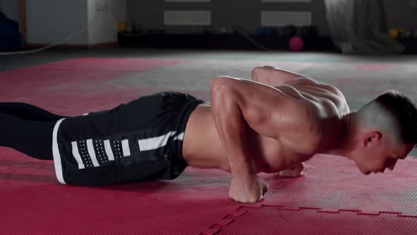 Young Shirtless Man Doing Pushups in the Gym