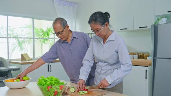 Asian strong older people husband and wife enjoy retirement life, cooking foods on table in house.