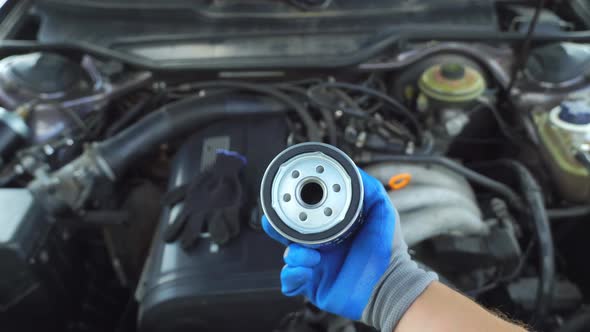 Oil Filter Replacement Car Engine Maintenance Mechanic Hands in Gloves Close-up