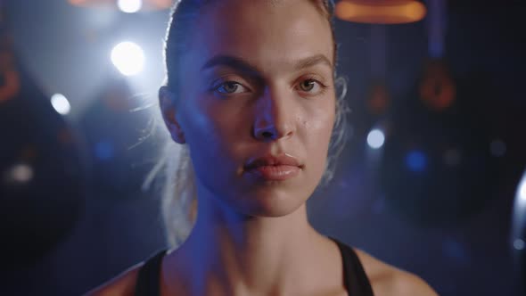 Portrait of the Sport Woman Looking at the Camera on the Sport Gym Background