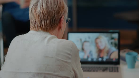 Grandmother Attending Online Video Call with Family on Laptop