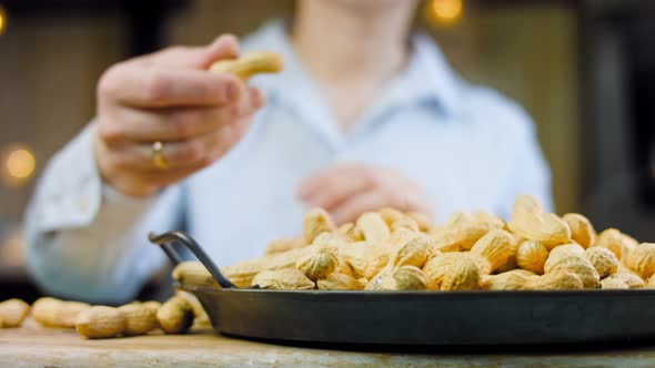 The Woman Peels the Peanuts From the Retro Tray