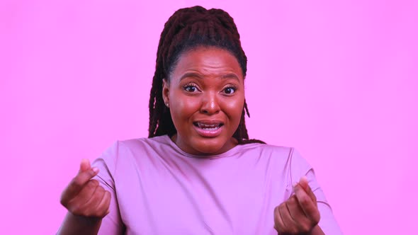 Dark Skinned Woman Laughing and Shooting Social Media Stories in Pink Wall Background