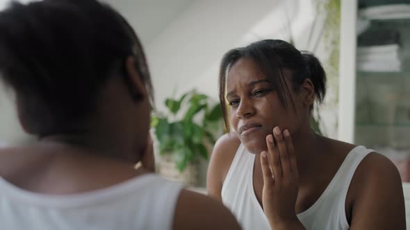 African-American woman  in the bathroom having a strong toothache or bruxism. Shot with RED helium c