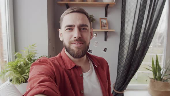 Bearded Young Caucasian Man Chatting on Video Call at Home