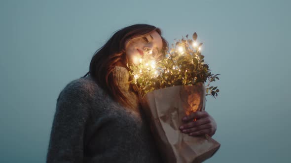 Sweet Girl Squeezes to Herself Bouquet of Flowers with Lights