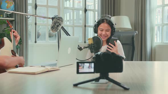 Camera Recording, Asian Kid Girl Holding Phone Singing Into Microphone While Recording Podcast