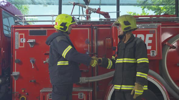 A successful group of caucasian firefighters or firemen team with uniform shaking hands,