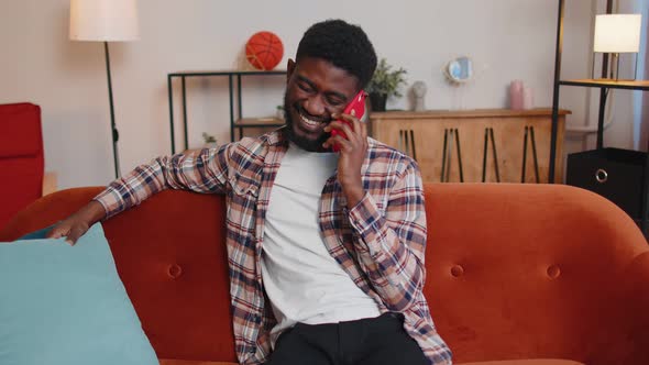 Young Adult African American Man Enjoying Talking Mobile Phone Conversation with Friends at Home