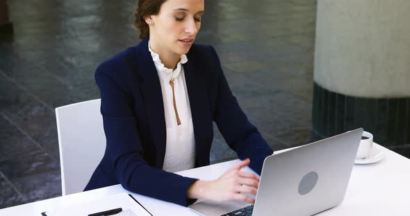 Businesswoman working on laptop at desk 4k