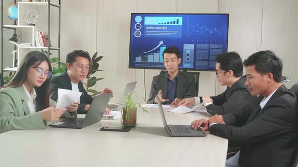 Asian Executive Explains Company's Vision And Potential To His Employees In The Conference Room