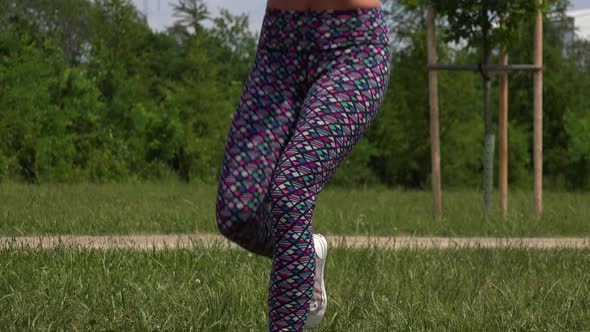 A Beautiful Fit Woman Does Assisted One-legged Squats at an Outdoor Gym - Closeup