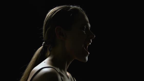 Humiliated Girl Screaming Against Black Background, Man Closing Her Mouth