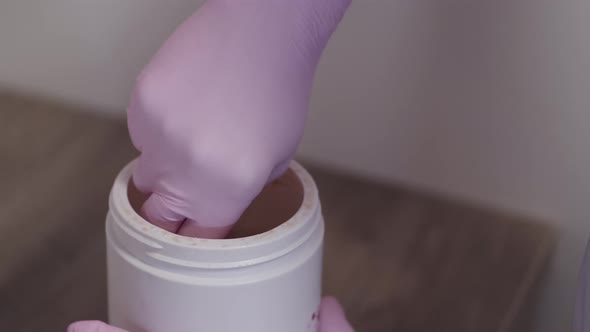 Cosmetologist Taking Wax Out of Box for Hair Removal Procedure