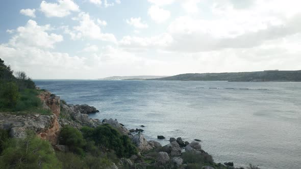 AERIAL: Panoramic Shot of Mellieha Bay on a Sunny Day with Fish Farm Nets Placed in Bay