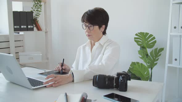 Creative Work and Hobby Concept Middleaged Woman Photo Editor Working on Computer at Her Desk with