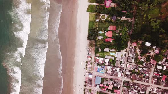 The Beautiful Island Of Olon Beach With Calm Sea and Different Buildings - Aerial Shot