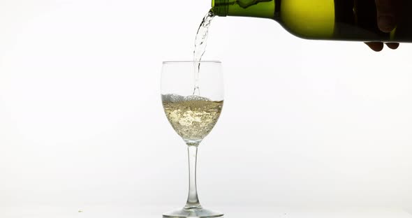 900121 White Wine being poured into Glass, against White Background, Slow motion 4K