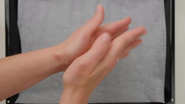 Top view of woman hands making  homemade cookies on a baking sheet